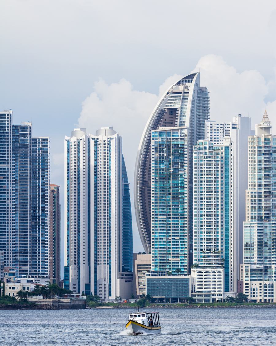 Residential towers of Punta Pacifica rising above the bay, with a small fishing boat in the foreground